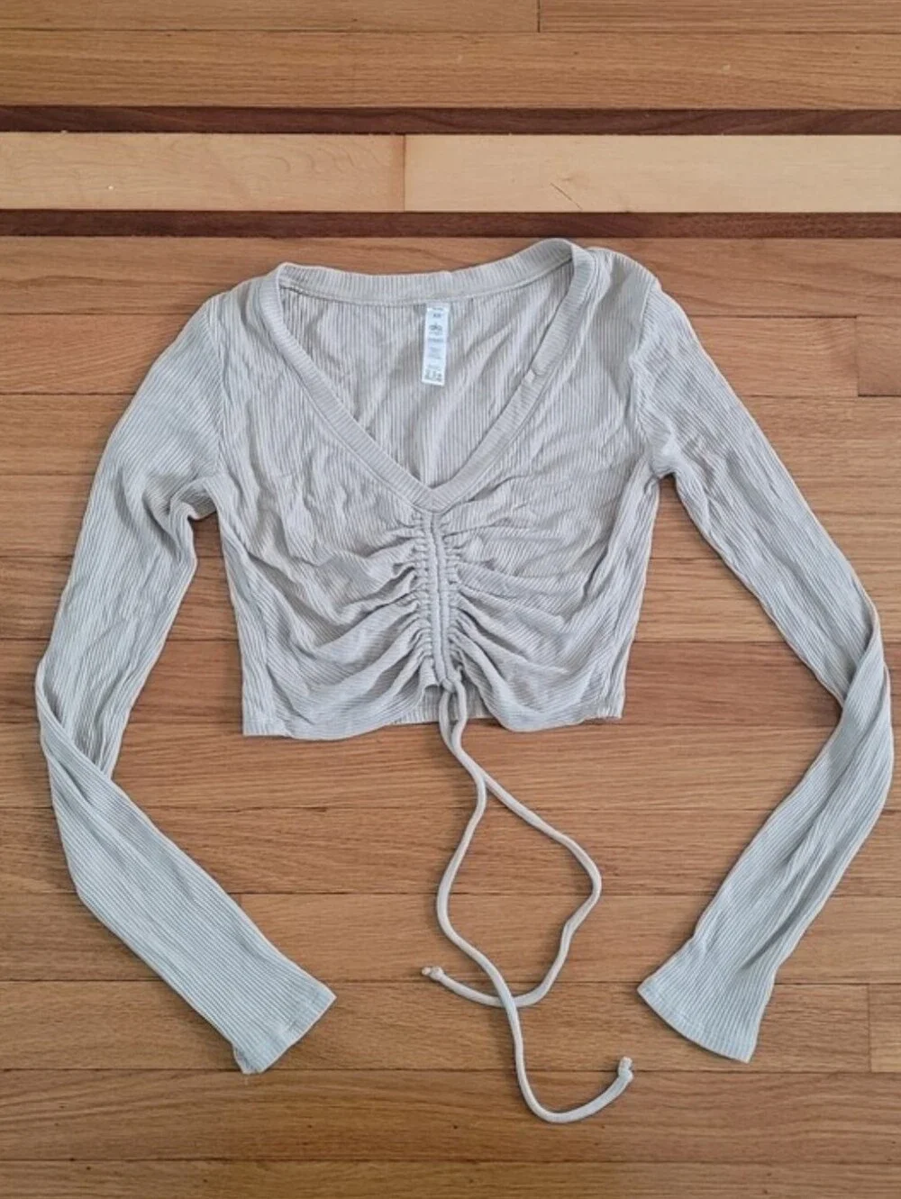 ALO YOGA RIBBED CINCH CROPPED LONG SLEEVE TOP IN CALIFORNIA SAND
